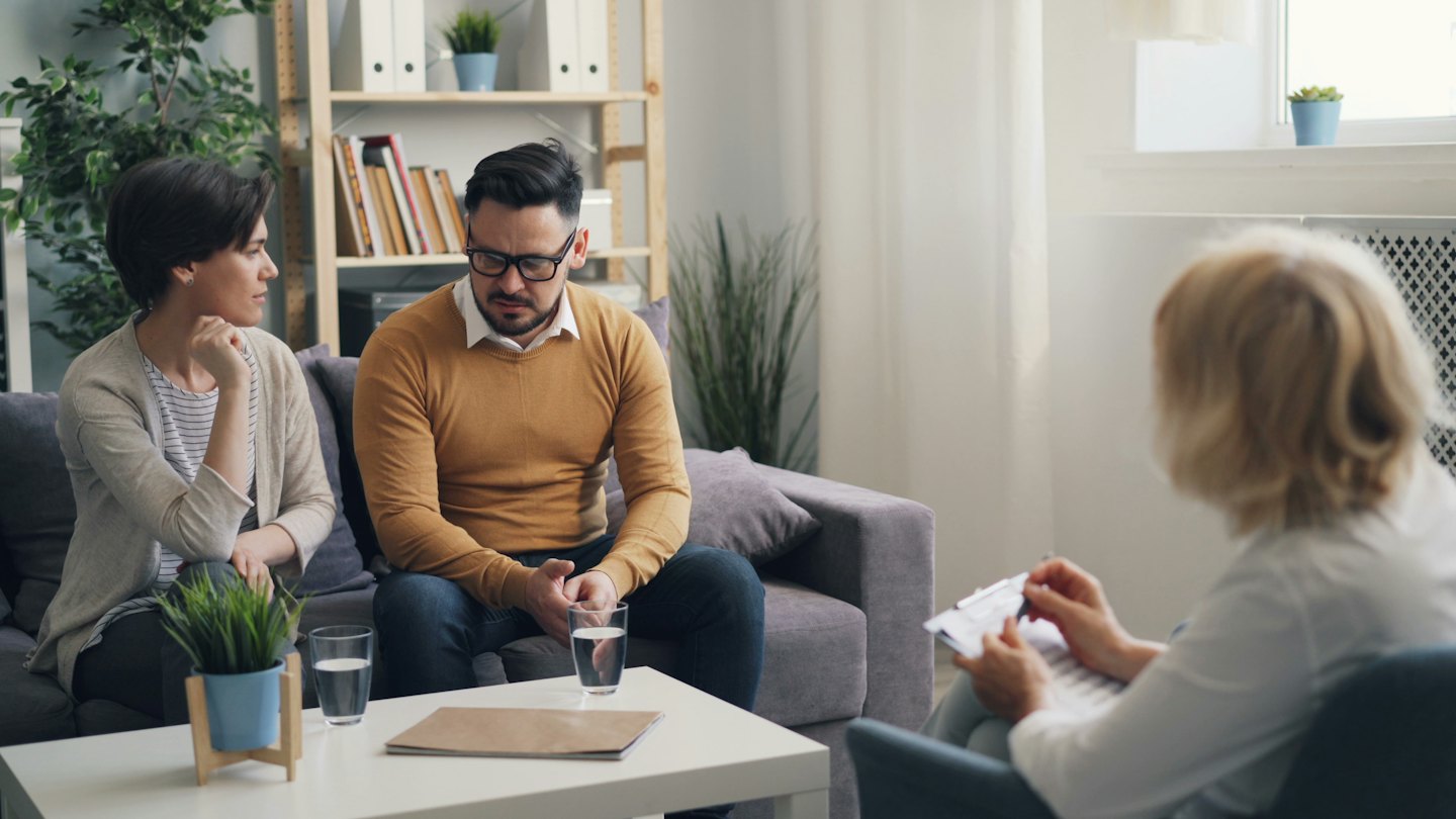 Man and woman at therapy session with counselor.